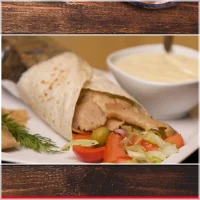 Kalfsvlees, geserveerd in een opgerolde wrap (turkse deegrol) sla en saus naar keuze