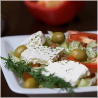 Ijsbergsla, tomaat, komkommer, ui, rucola, olijven en fetakaas